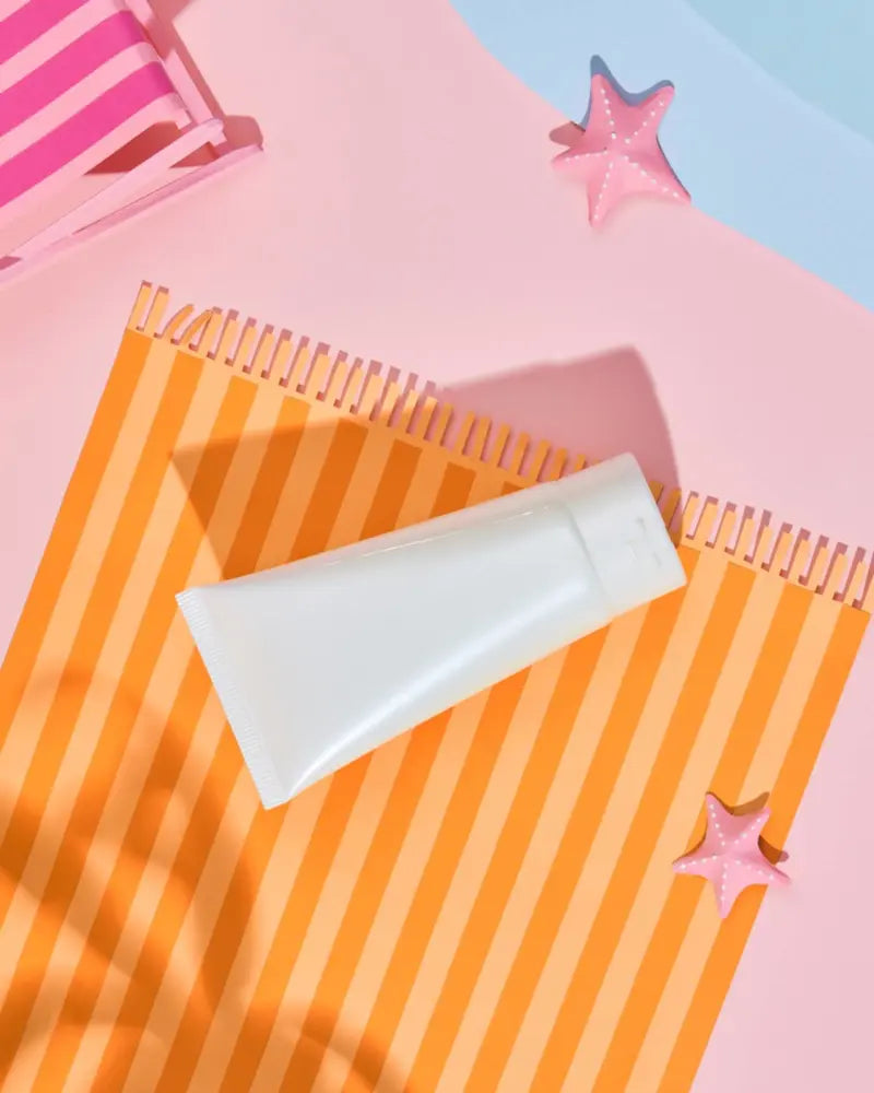 A white tube of cream on a striped orange towel