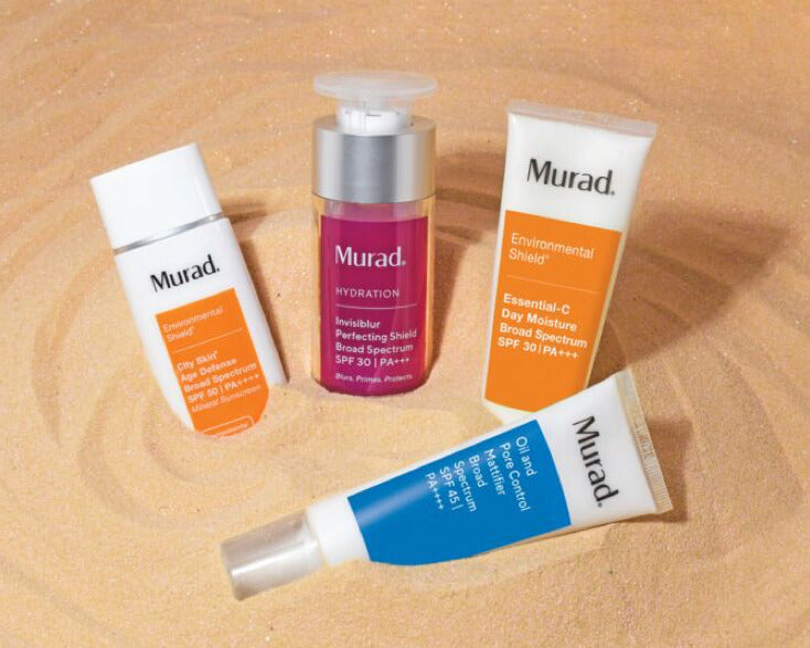a group of murad skincare products in the sand