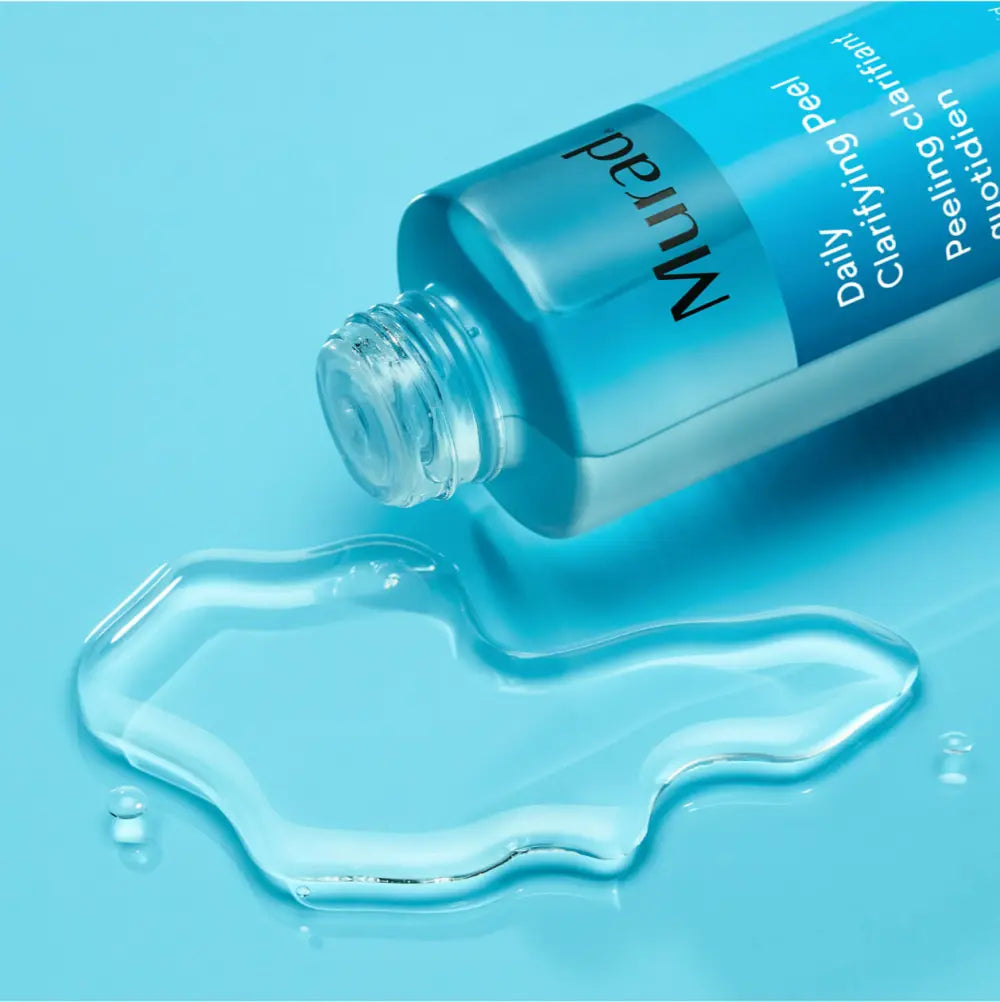 A bottle of Daily Clarifying Peel next to a puddle of it's own liquid