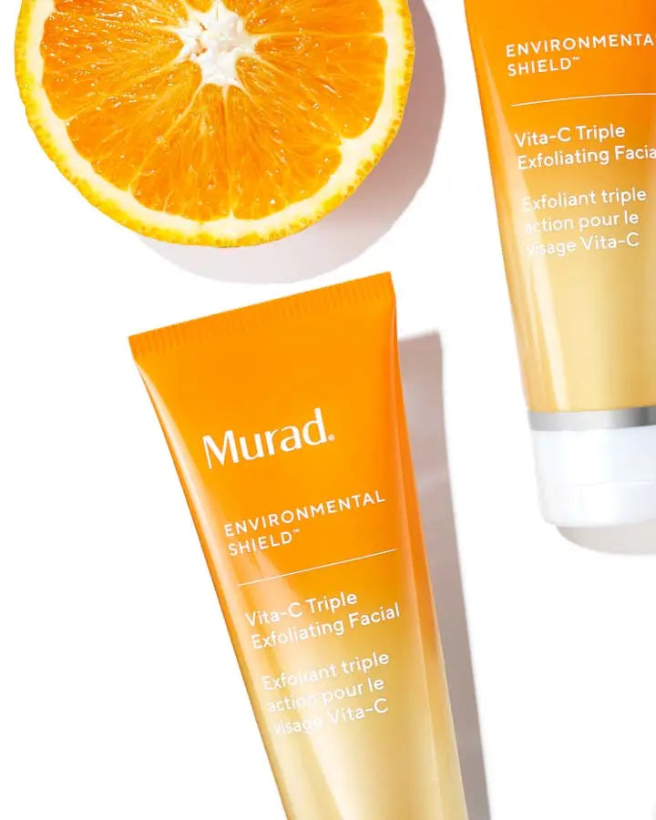a orange slice next to a bottle of Vita-C Triple Exfoliting Facial