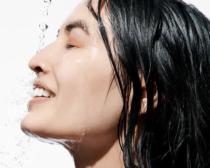 A person washing her face with water