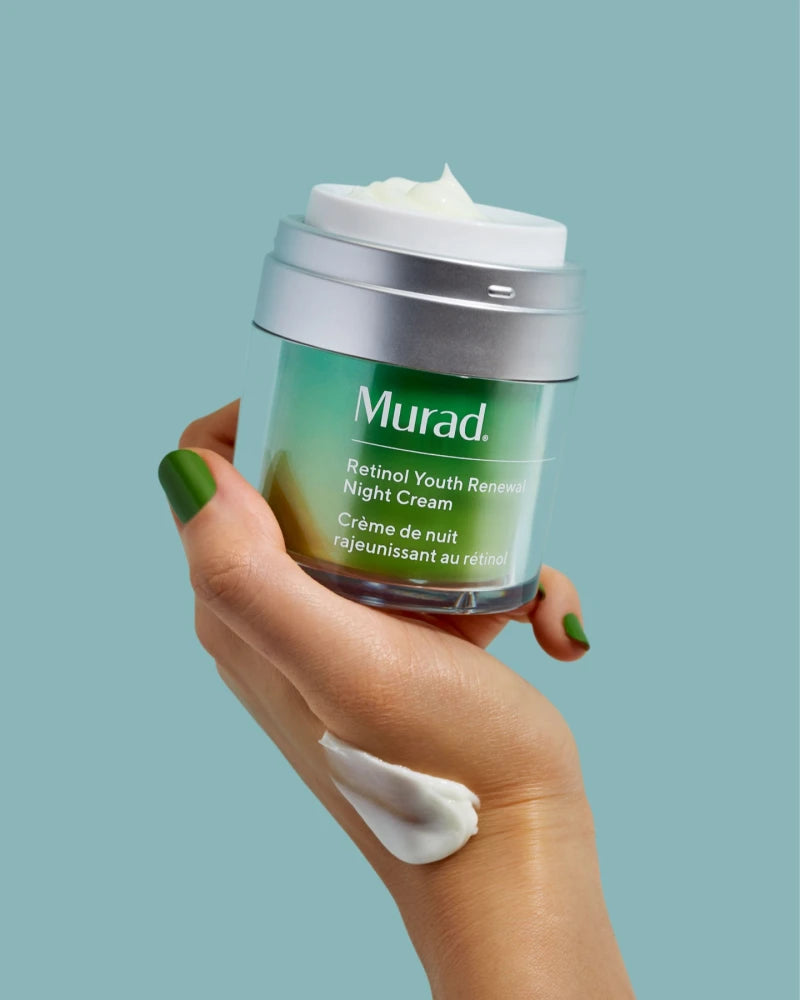 A close up of a hand holding a tub of Retinol Youth Renewal Night Cream