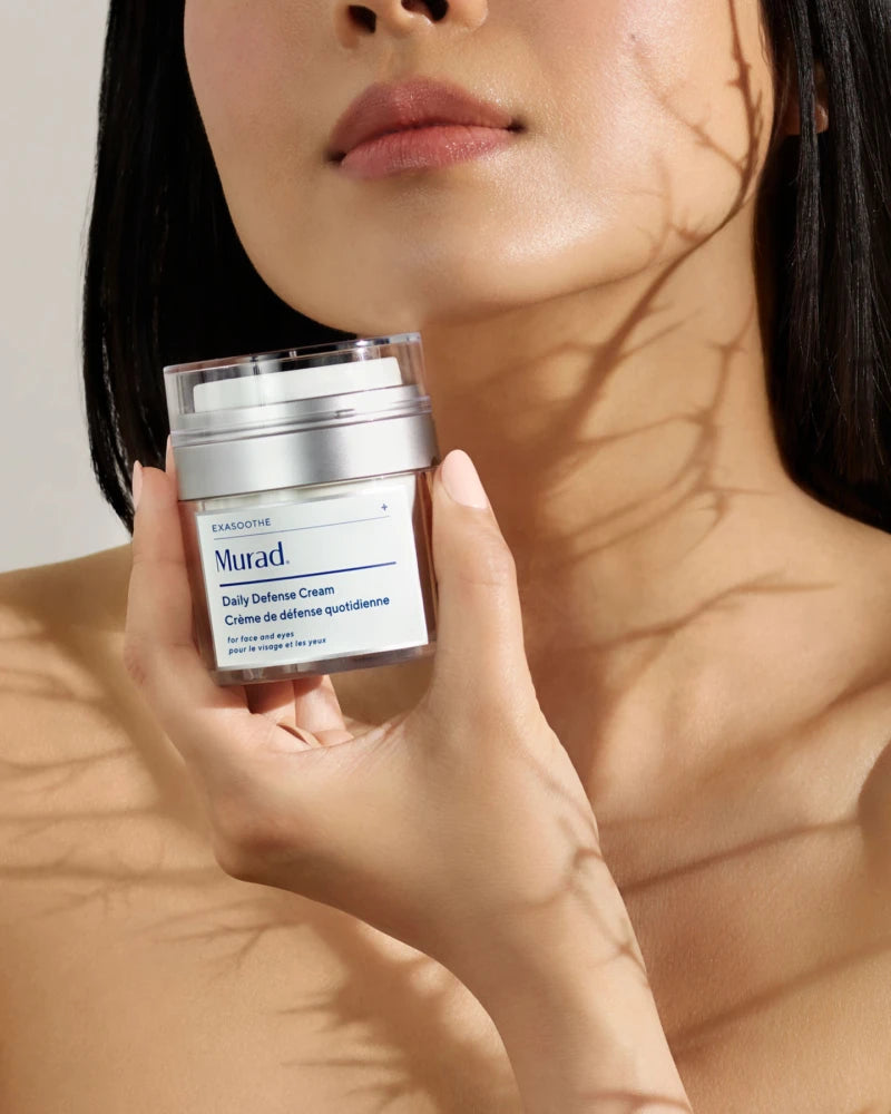 A person holding a jar of Daily Defence Cream
