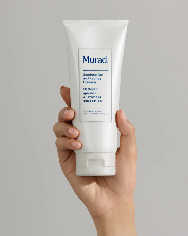 A and holding a tube of Soothing Oat and Peptide Cleanser