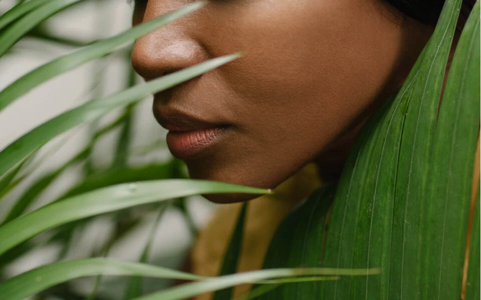 A close up of a person's face next to plants
