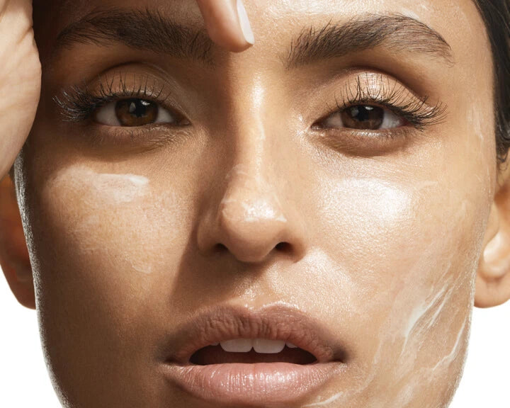 a close up of a person's face with cream on her face